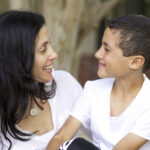 Smiling woman and child facing each other