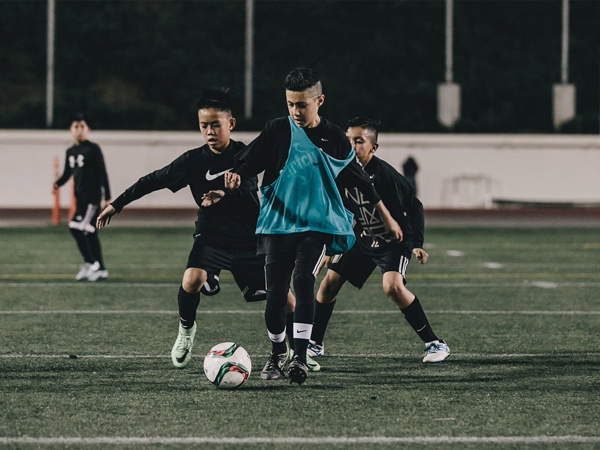 Youth soccer match under stadium lights.